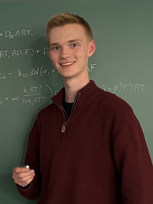 Neil Gabrielson standing in front of a blackboard